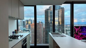 Une cuisine moderne dotée d’une grande fenêtre donnant sur un paysage urbain.