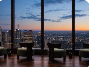 A room with large windows offering a cityscape view at dusk. - 2-Bedroom, 2-Bathroom High-Rise Apartment | Panoramic Views | Southbank (Southbank)