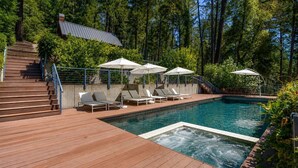 A swimming pool with a wooden deck, lounge chairs, and umbrellas. - The Ridge at Mill Creek- Hot Tub, Pool & Tastings (Healdsburg)