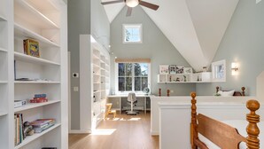 A room with a sloped ceiling, a desk with a chair, and a bed with a wooden headboard. - The Ridge at Mill Creek- Hot Tub, Pool & Tastings (Healdsburg)