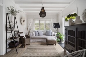 A room with a sofa, a ladder, a television, and a cabinet. - Six and Twenty by Waiheke Pure (Waiheke Island)