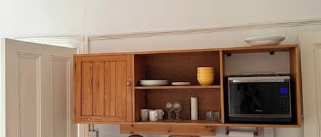 A kitchen with wooden cabinets, a microwave, and a toaster.