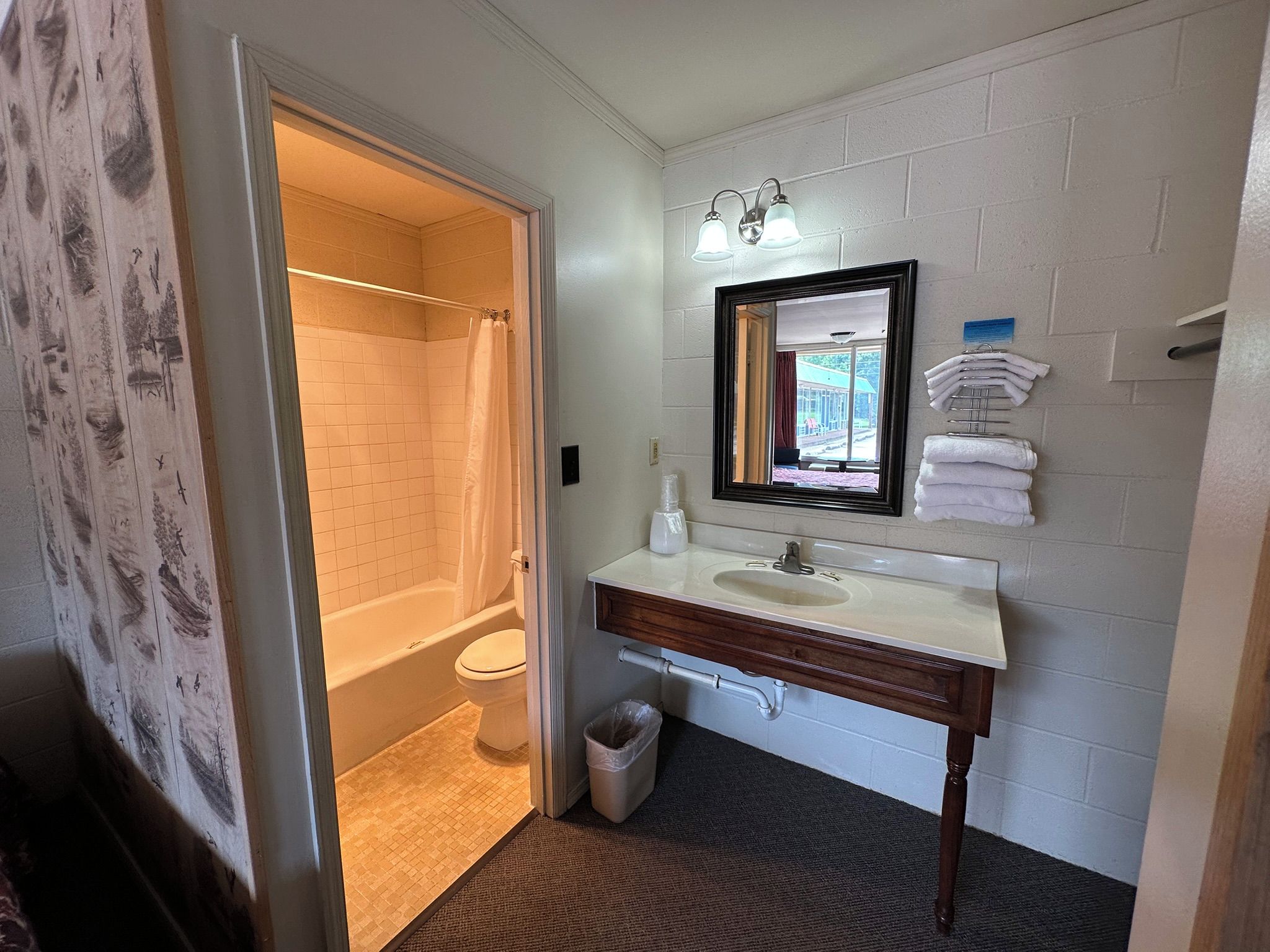 Une salle de bain avec une baignoire, des toilettes, un lavabo et un miroir.