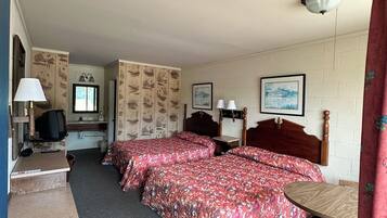 Une chambre d’hôtel avec deux lits, un bureau, une télévision et une fenêtre.
