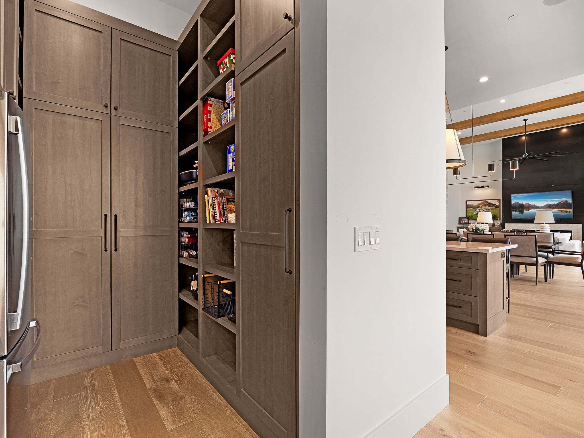 A modern kitchen with built-in cabinets, a central island, and a dining area with chairs.