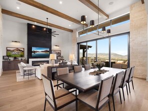 A spacious dining area with a large table, chairs, and a fireplace. - Timpanogos View Estate at Red Ledges (Heber City)