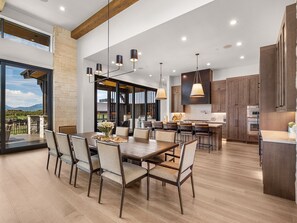 Une cuisine spacieuse, dotée d’appareils électroménagers modernes, et un coin repas avec une grande table et des chaises.