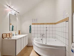 A bathroom with a white sink, mirror, and a freestanding bathtub. - 8 Person Holiday Home in Egernsund (Broager)