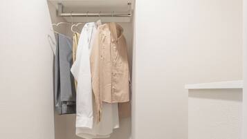 A small, narrow closet with a wooden floor and a white wall.
