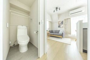 Un interior moderno con inodoro, sofá y zona de cocina.