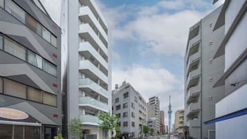 En modern stadsgata med höga byggnader, klar himmel och en gångbana för fotgängare.