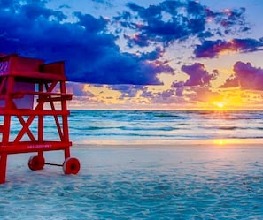 A lifeguard tower on a beach with the ocean and a sunset in the background. - Hibiscus Hideaway - Coastal Retreat by the Beach (Ormond Beach)