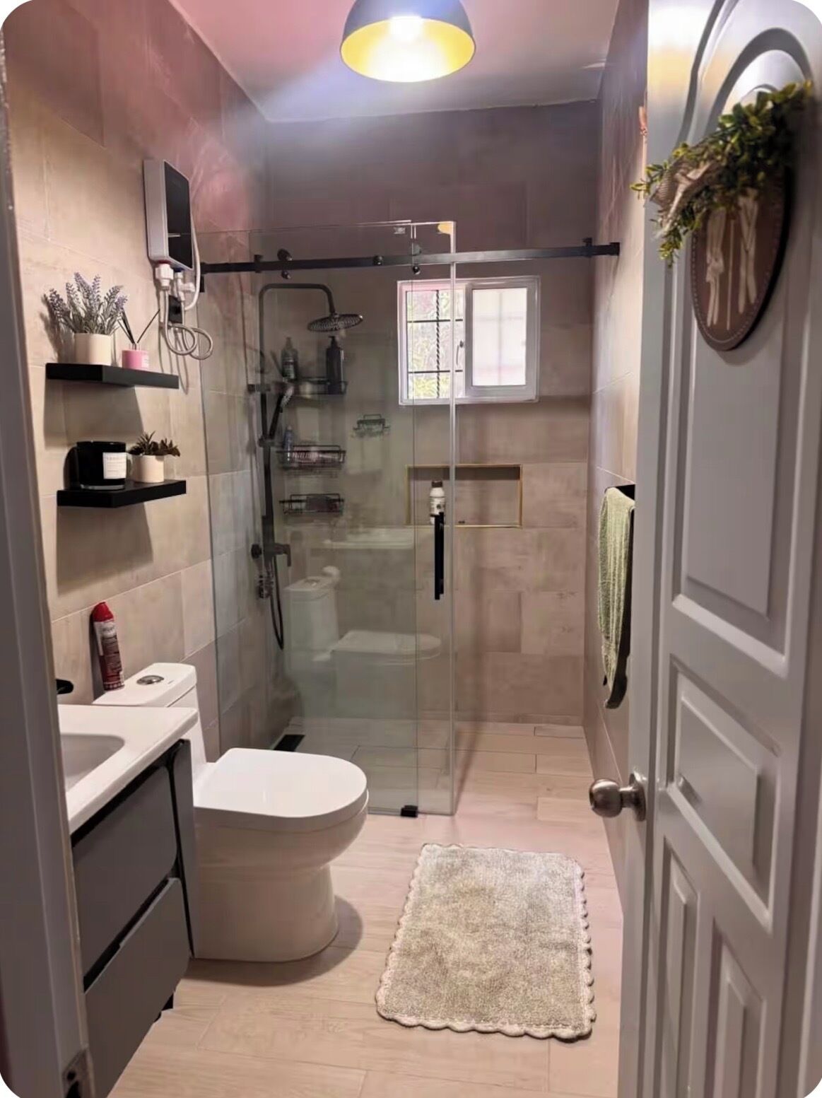 Une salle de bain moderne équipée de toilettes, d’une douche et d’un espace de douche vitré.