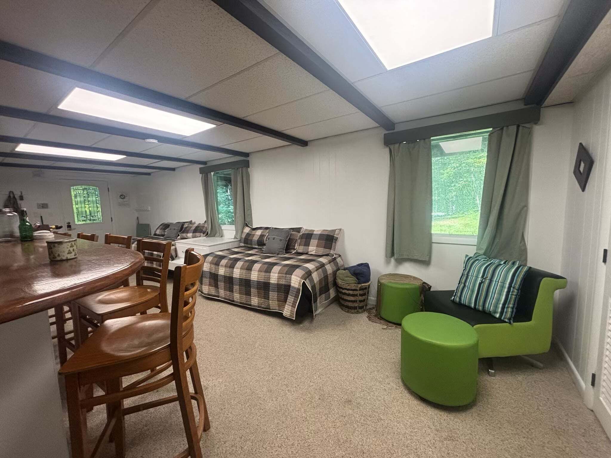 Une pièce comprenant un lit, un canapé, une table à manger avec des chaises et une fenêtre avec des rideaux.