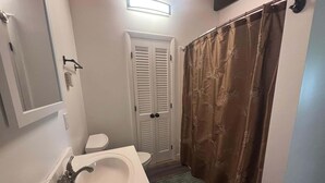 Une salle de bain avec un lavabo blanc, des toilettes et un rideau de douche.