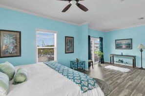 A bedroom with a bed, a desk, a chair, a window with blinds, a ceiling fan, and a view of the outside. - Canal Home: Private Pool, Hot Tub, Dock and Pilings (Marathon)