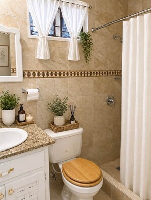 A bathroom with a toilet, sink, and shower area. - 87 Suites | The Haven – Modern 1BR in West Village (Montego Bay)