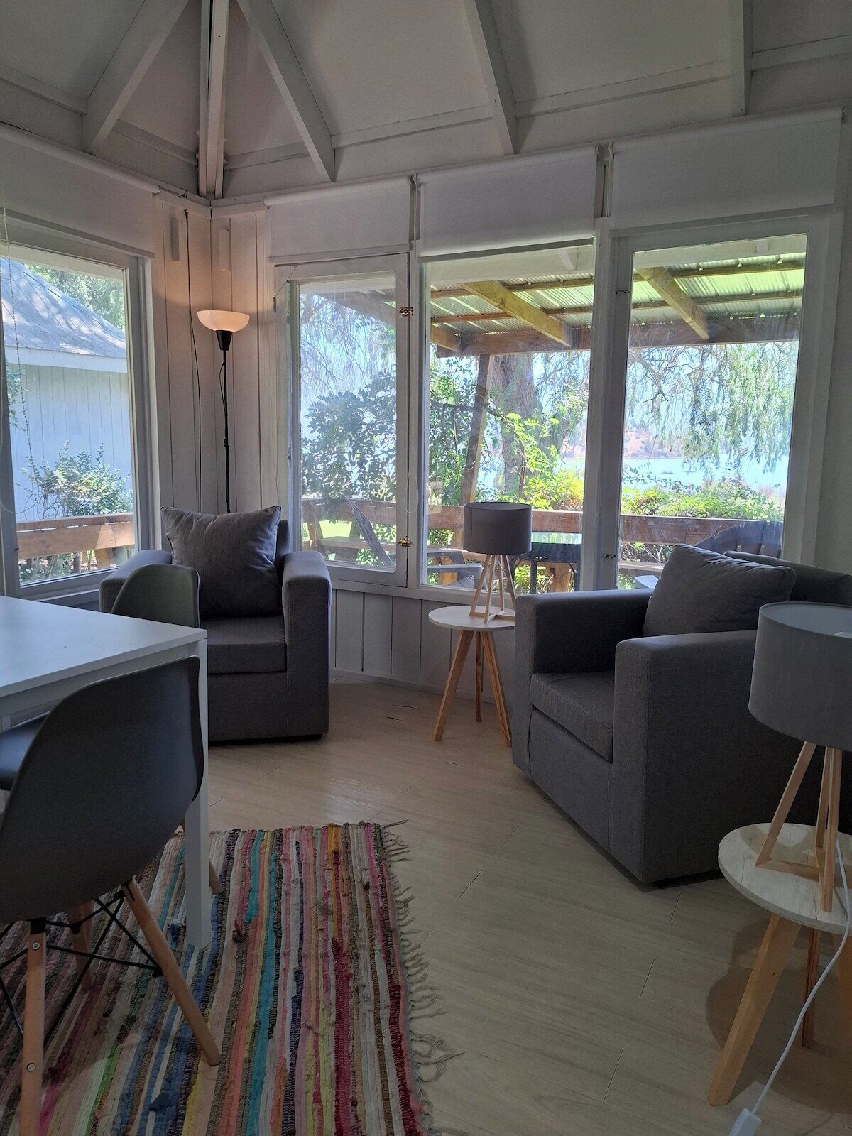 Una sala de estar moderna con un sofá, una mesa de comedor y una alfombra.