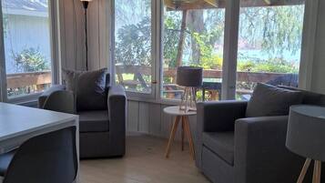 Una sala de estar moderna con un sofá, una mesa de comedor y una alfombra.