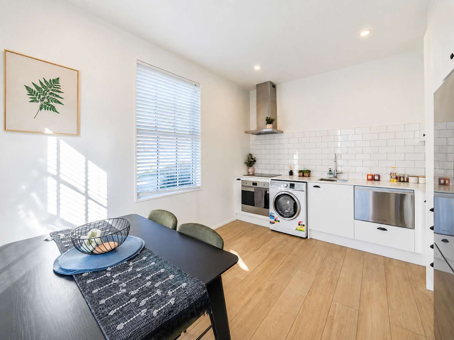 A compact kitchen with a washing machine, a sink, and a stove.