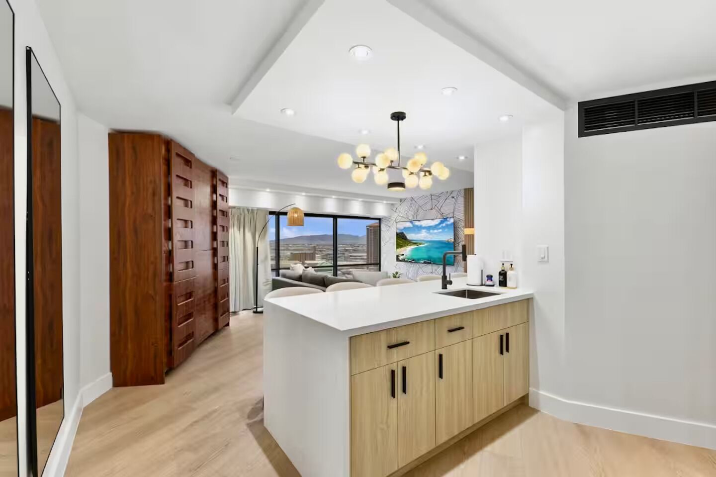 A modern kitchen with a central island, wooden cabinets, and a view of the outdoors.