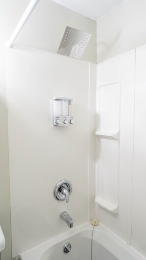 A bathroom with a shower, a toilet, and a bathtub.