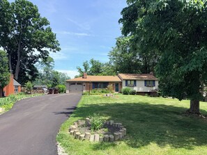 A residential house with a garage, a front yard with a flower bed, and a driveway leading to the house.