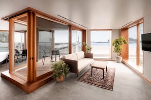 En moderne stue med sofa, sofabord og potteplanter.