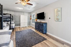 A bedroom with a bunk bed, a ceiling fan, a TV, and a dresser. - Miramar Home with Private Pool, Large Deeded Beach Access, Bikes & Paddleboards (Miramar Beach)