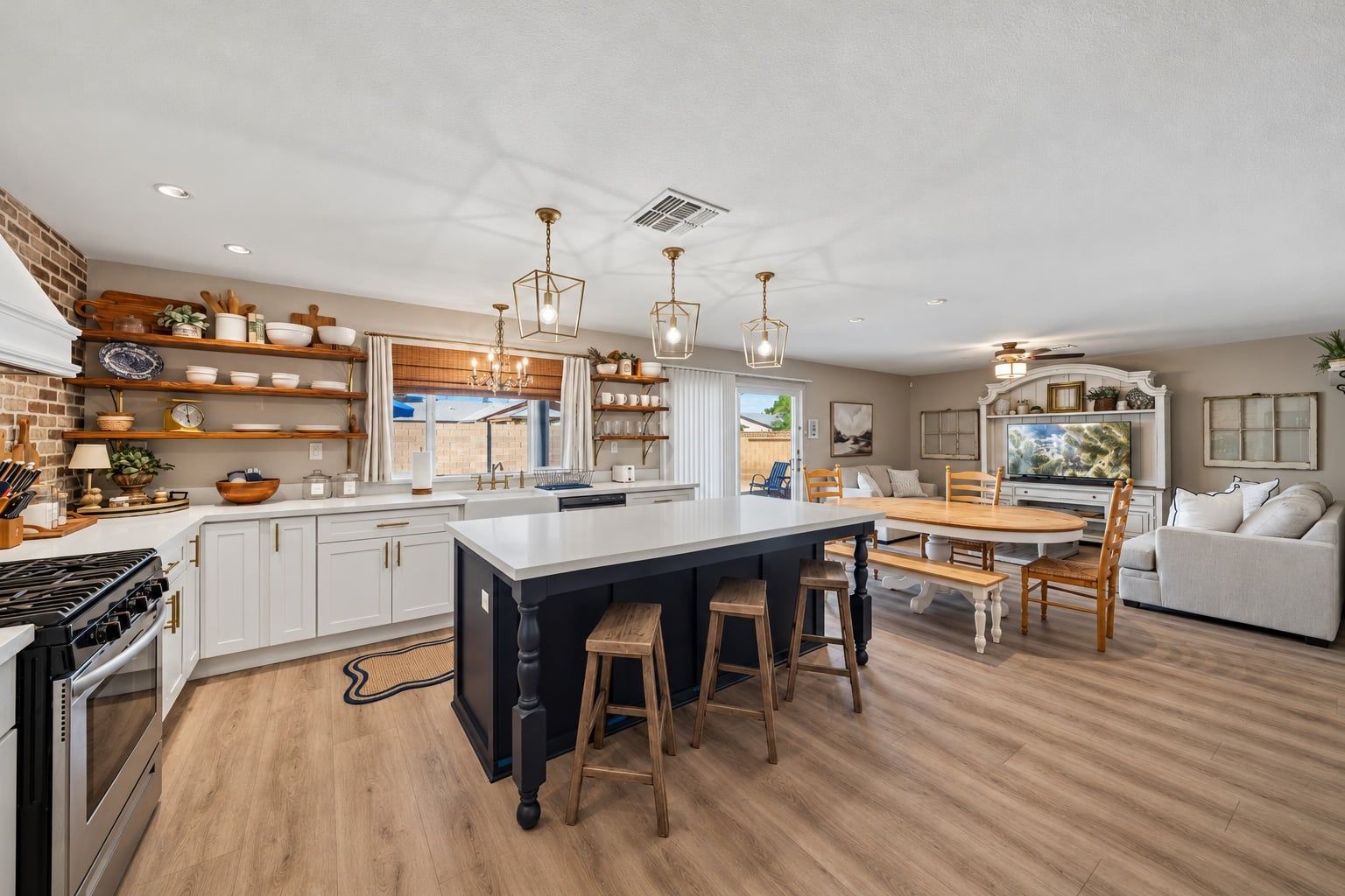 Una cocina moderna con una isla central, taburetes de madera e iluminación colgante.