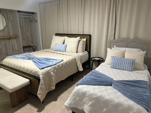 A hotel room with two beds, a bench, a small table, and a mirror. - Pleasant 3-bedroom house with AC in charming Cocoa (Cocoa)