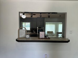 A kitchen with a built-in microwave, a coffee maker, and a toaster. There is a welcome sign and a notes book on the counter. - Pleasant 3-bedroom house with AC in charming Cocoa (Cocoa)