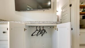 A kitchen with a granite countertop, a built-in microwave, and a hanging rack for utensils. - #7 | Modern SPI Beach Studio + Pool | Smart TV (South Padre Island)