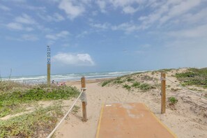A sandy beach path leading to the ocean with a wooden boardwalk and ropes for safety. - #7 | Modern SPI Beach Studio + Pool | Smart TV (South Padre Island)