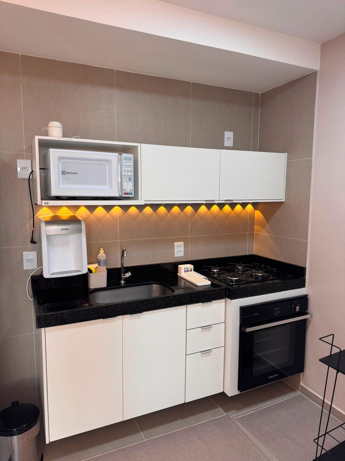 Une cuisine moderne équipée d’un four à micro-ondes, d’une cuisinière et d’un four encastré.