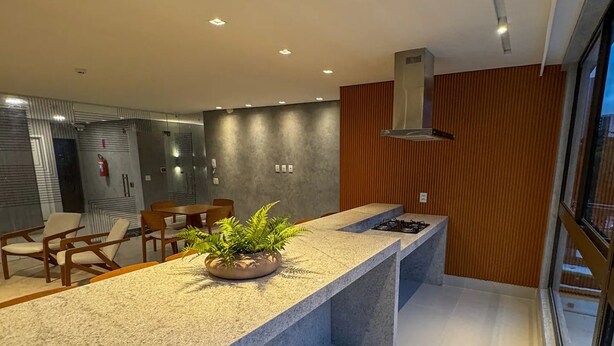 Een moderne keuken met een groot eiland, inbouwapparatuur en uitzicht op buiten.