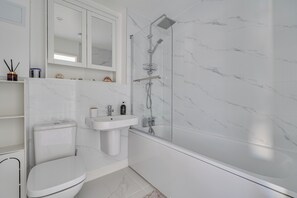 A modern bathroom with a toilet, sink, and shower.