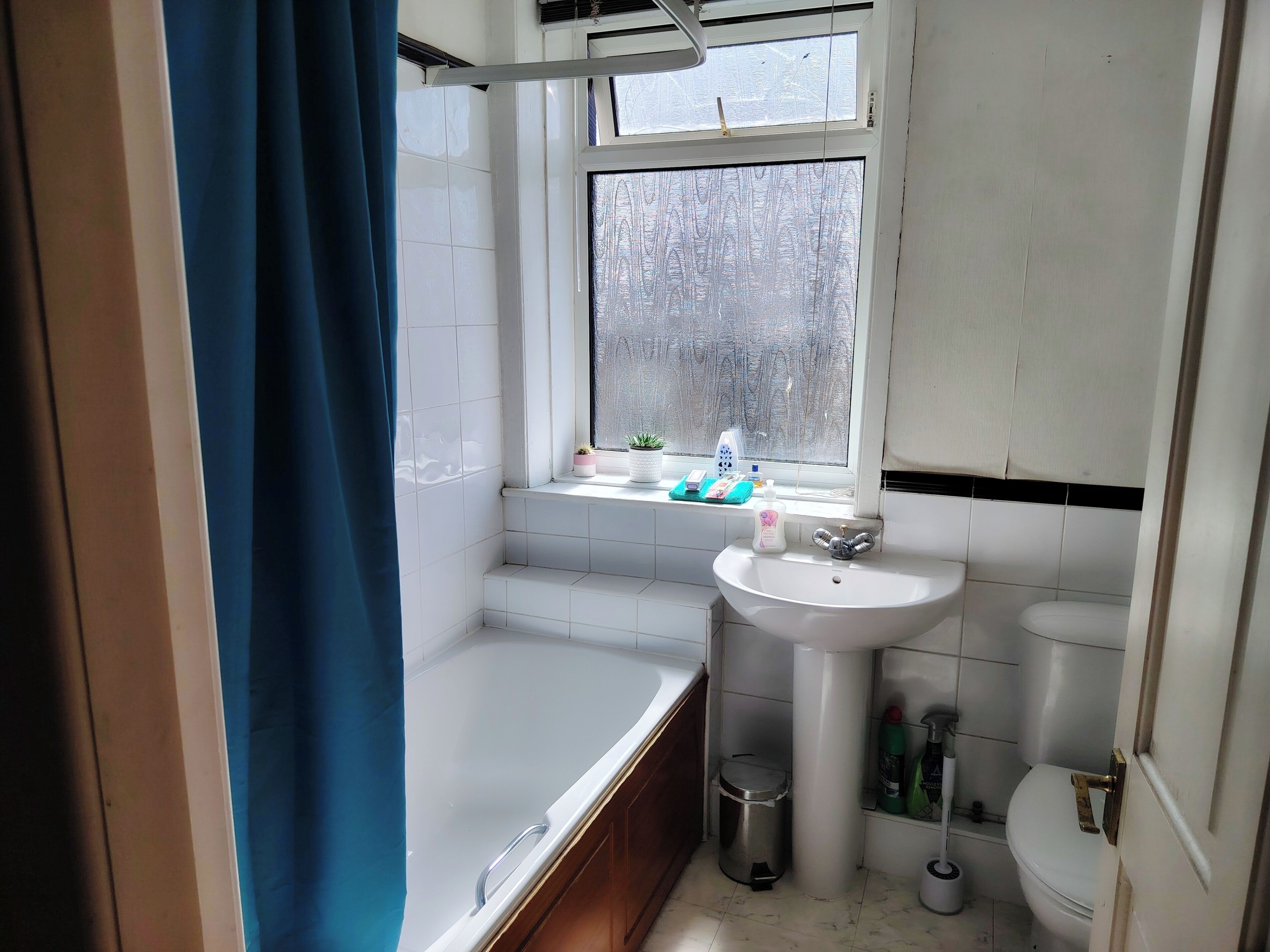 Un baño con bañera, lavabo, inodoro y ventana.