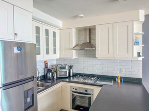 A modern kitchen with white cabinets, a stainless steel refrigerator, a gas stove, and a built-in oven. - Boana Torre Malibu #803 , Ocean view, romantic zone (Puerto Vallarta)