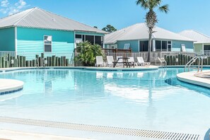 A swimming pool with lounge chairs and a palm tree. - White Sands Beach House Sleeps 10 with Pool (Gulf Shores)