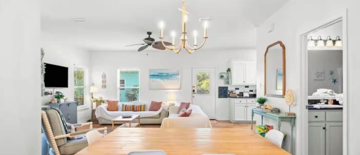 Un vaste espace de vie comprenant une table à manger, des canapés et un ventilateur de plafond.