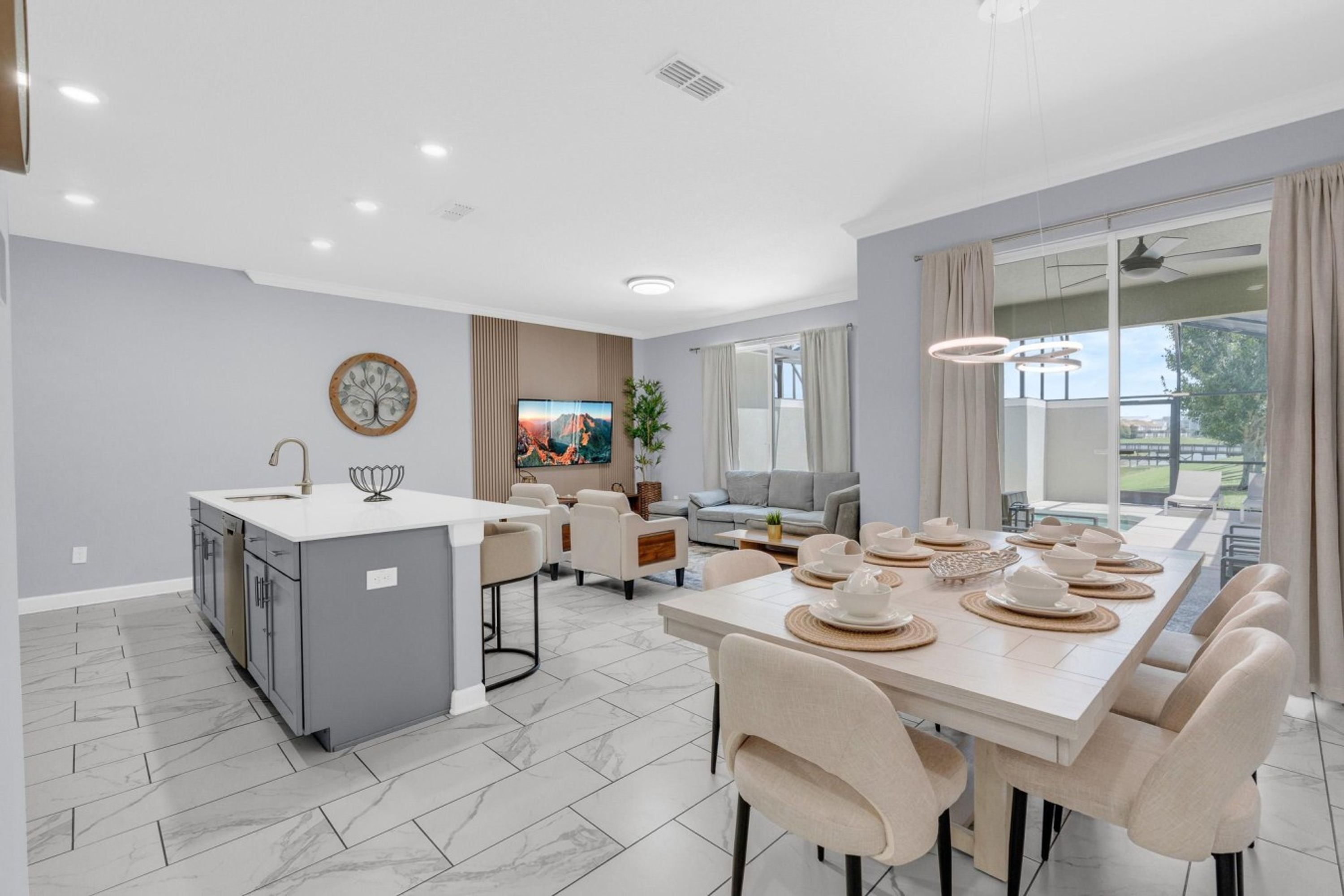 A modern kitchen with a dining area, a large window, and a view of the outdoors.