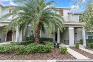 A residential building with a palm tree in the front yard. - Renovated 4 BDR With pvt Pool (Kissimmee)