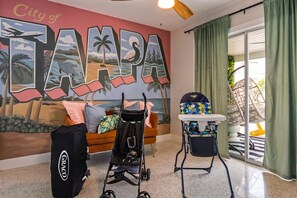 Ein Zimmer mit einer Wandmalerei von Tampa, einem Kinderwagen, einem Baby-Sitz und einer Tasche der Marke Graco.