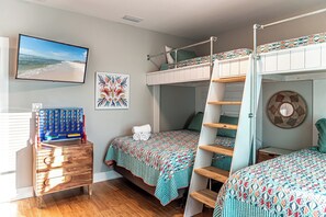 A bedroom with bunk beds, a desk with a computer, a wall-mounted TV, and a framed artwork. - 4005 Rookery 3 Sea Story two pools close to beach (Gulf Shores)