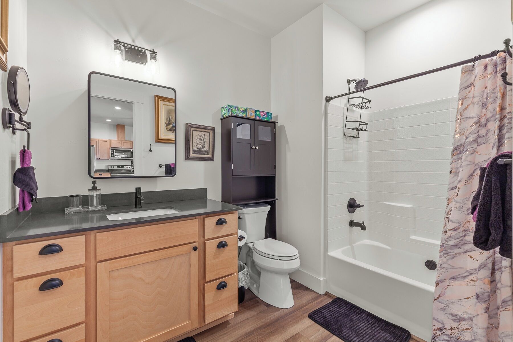 A modern bathroom with a vanity, toilet, and shower.