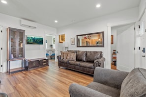 A living room with a brown leather sofa, a grey armchair, and a wooden cabinet. - Fabulous 2-bedroom condo in welcoming Ponderay (Ponderay)