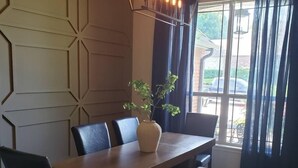 A dining area with a wooden table, chairs, a bench, and a potted plant. - Spacious Bixby Home w/ Fire Pit & Sleeps 12+ (Bixby)