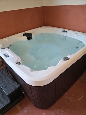 Ein Whirlpool mit Bedienfeld und einer Pumpe.
