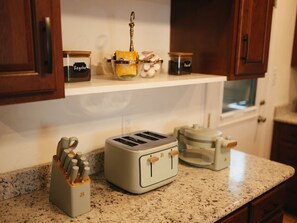A kitchen with a toaster, a spice rack, and a coffee maker on the counter. - Hot tub + Gameroom + Yard Firepit near White sands (Alamogordo)